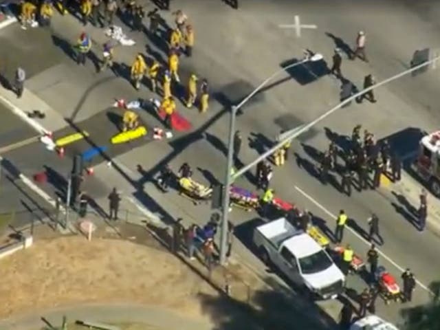 First responders gather on a nearby street corner as victims are treated outside a social services center in San Bernardino