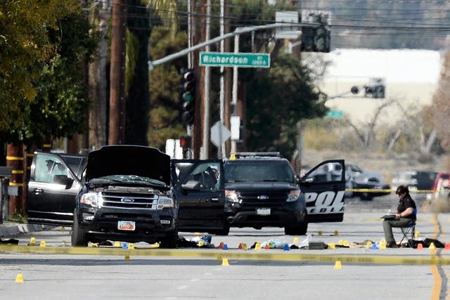 Evidence tags and debris surround the SUV thought to be the getaway vehicle of the husband and wife gunmen in the mass shooting