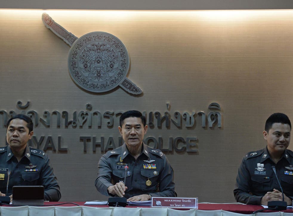 Thai deputy police spokesman Major General Songpol Wattanachai sits with colleagues during a press conference