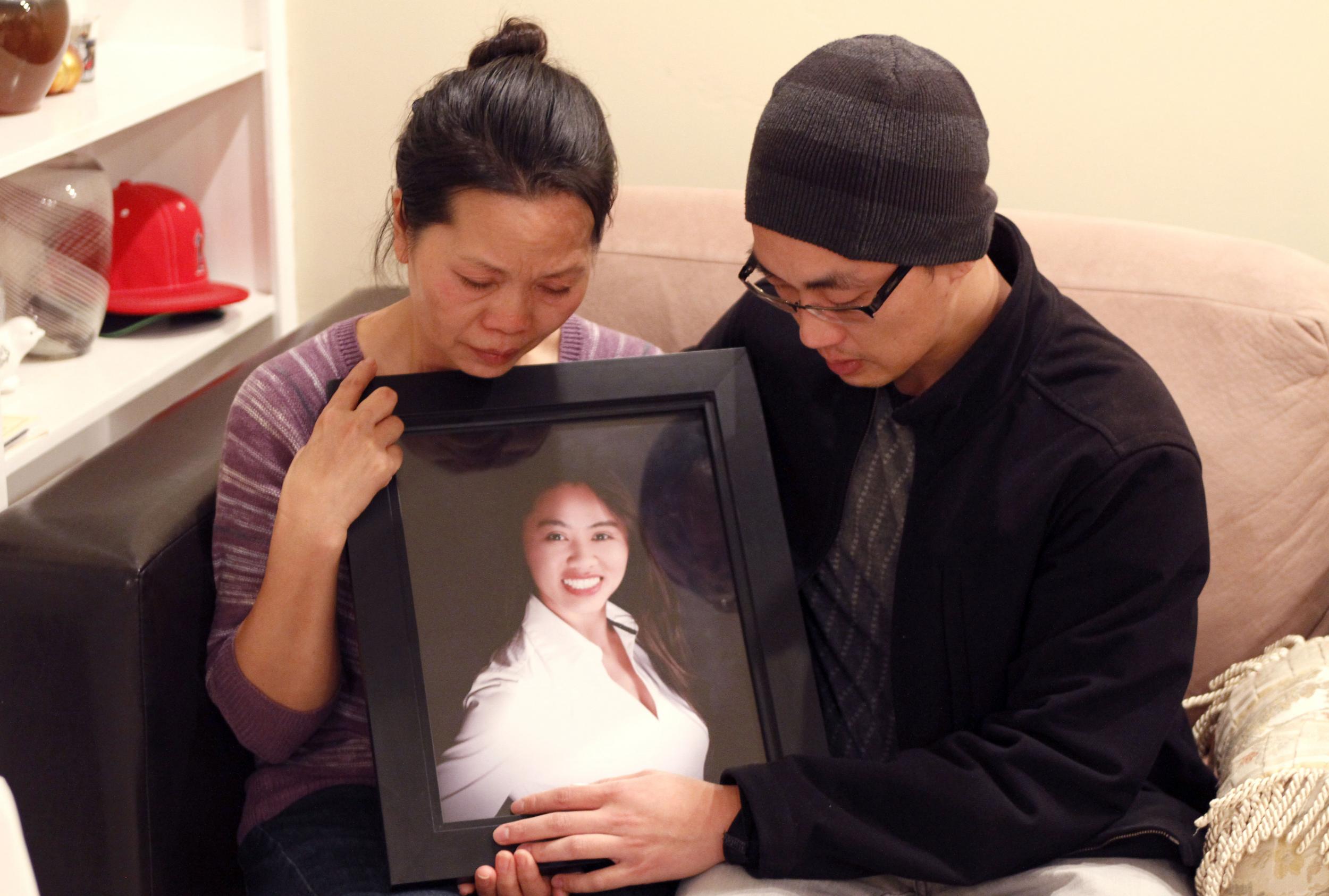 Vanessa Nguyen, the mother, and Trung Do, the brother, hold a photograph of Tin Nguyen.