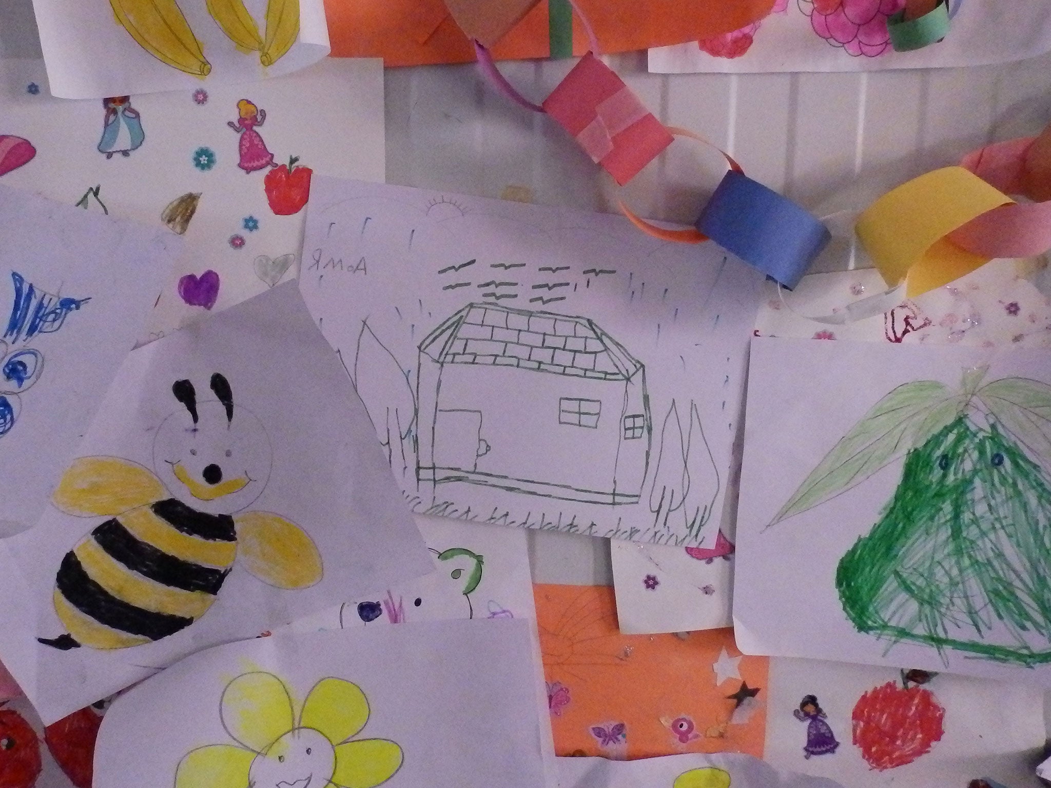Houses can be seen among the pictures drawn by children at a centre run by Save the Children at Kara Tepe refugee camp, Lesbos, in November 2015