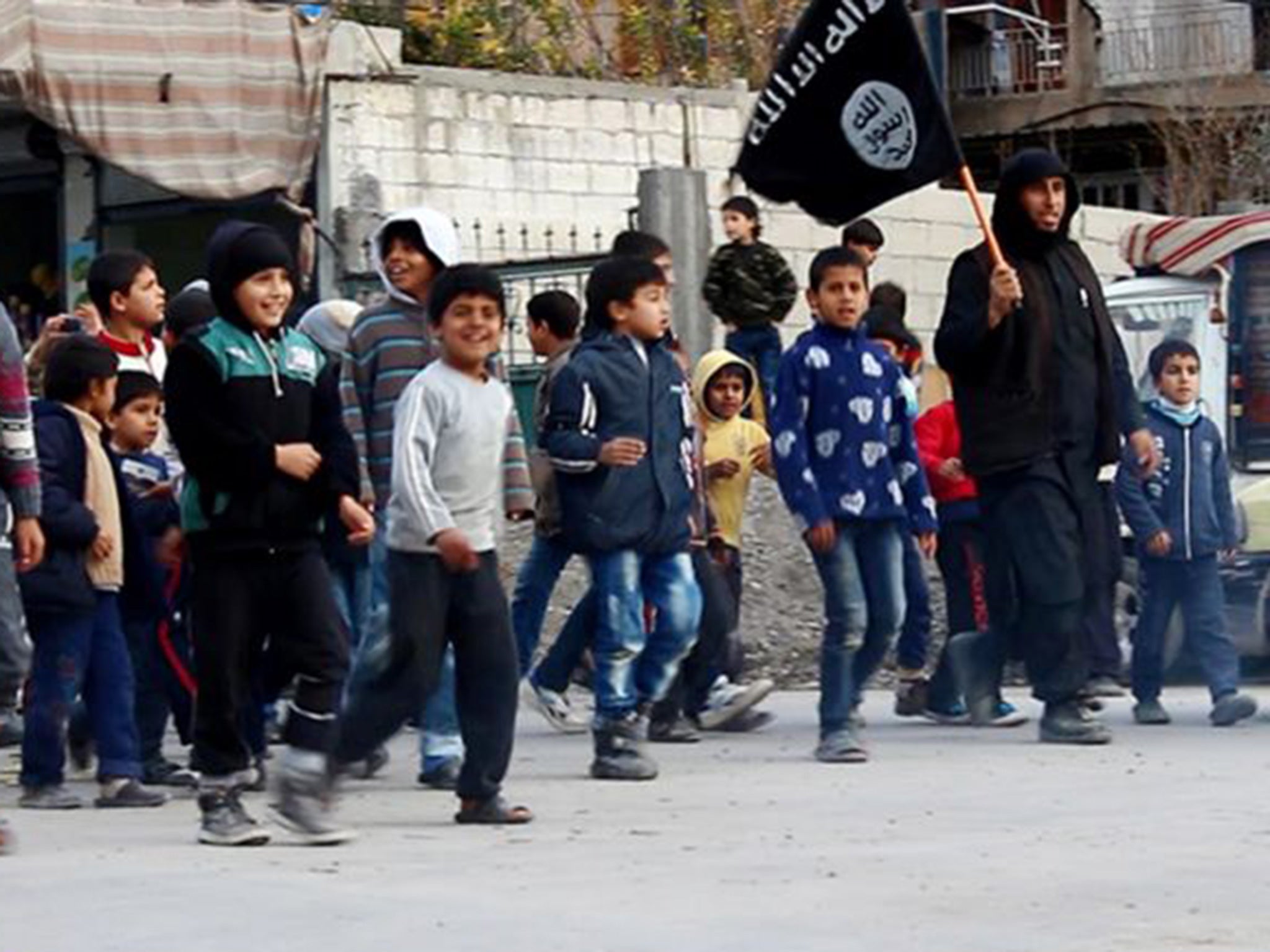 Syrian boys follow an Isis militant in Raqqa