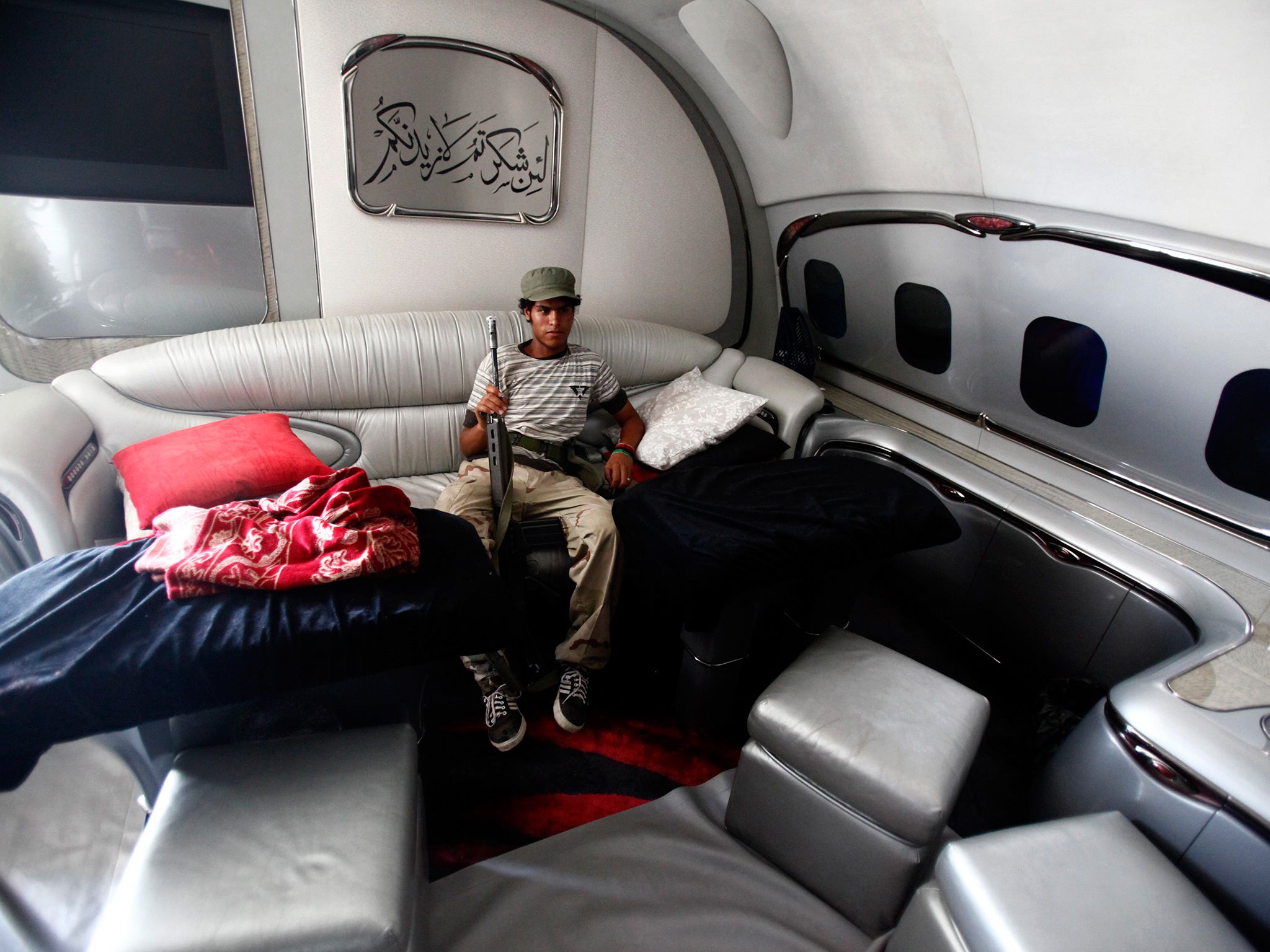A Libyan rebel fighter relaxes inside the jet in Tripoli in 2011