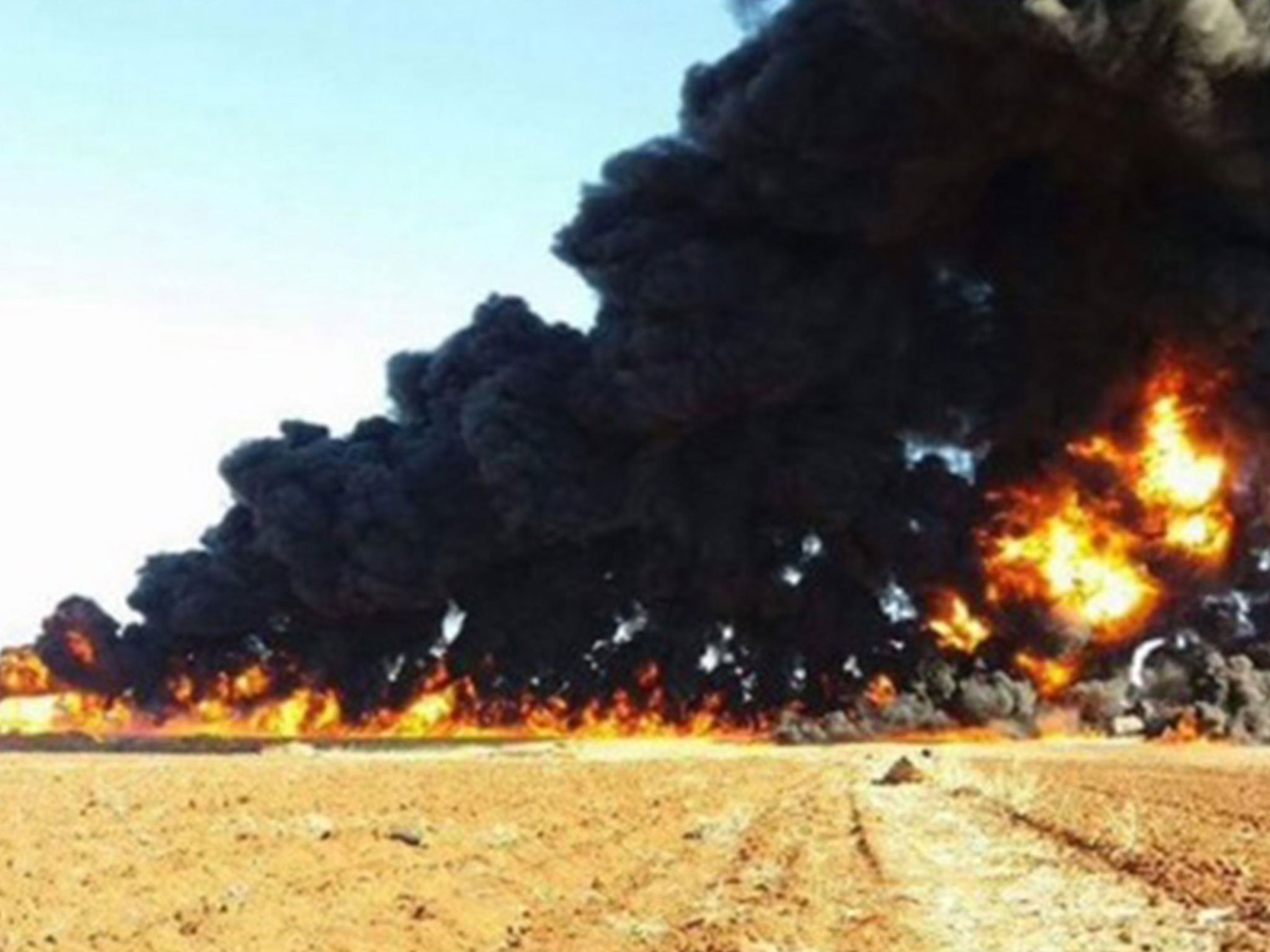 Thick black smoke billowing into the sky from the remains of the oil tanker after it was hit by a Russian air strike