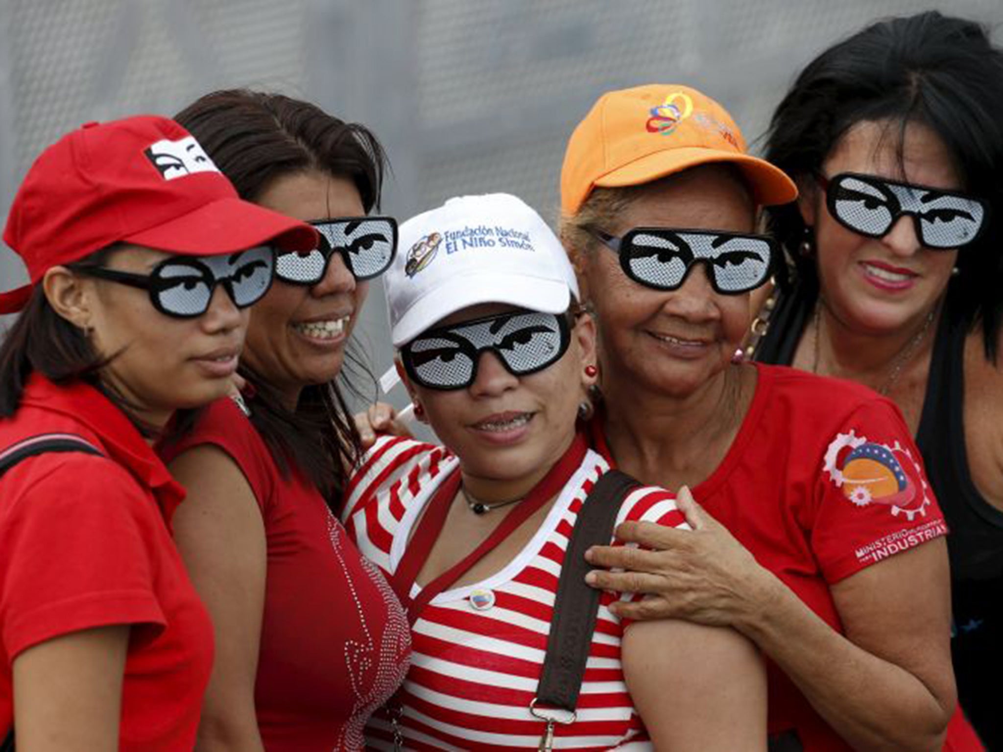 Supporters of President Nicolas Maduro wear glasses depicting the eyes of the late Hugo Chavez
