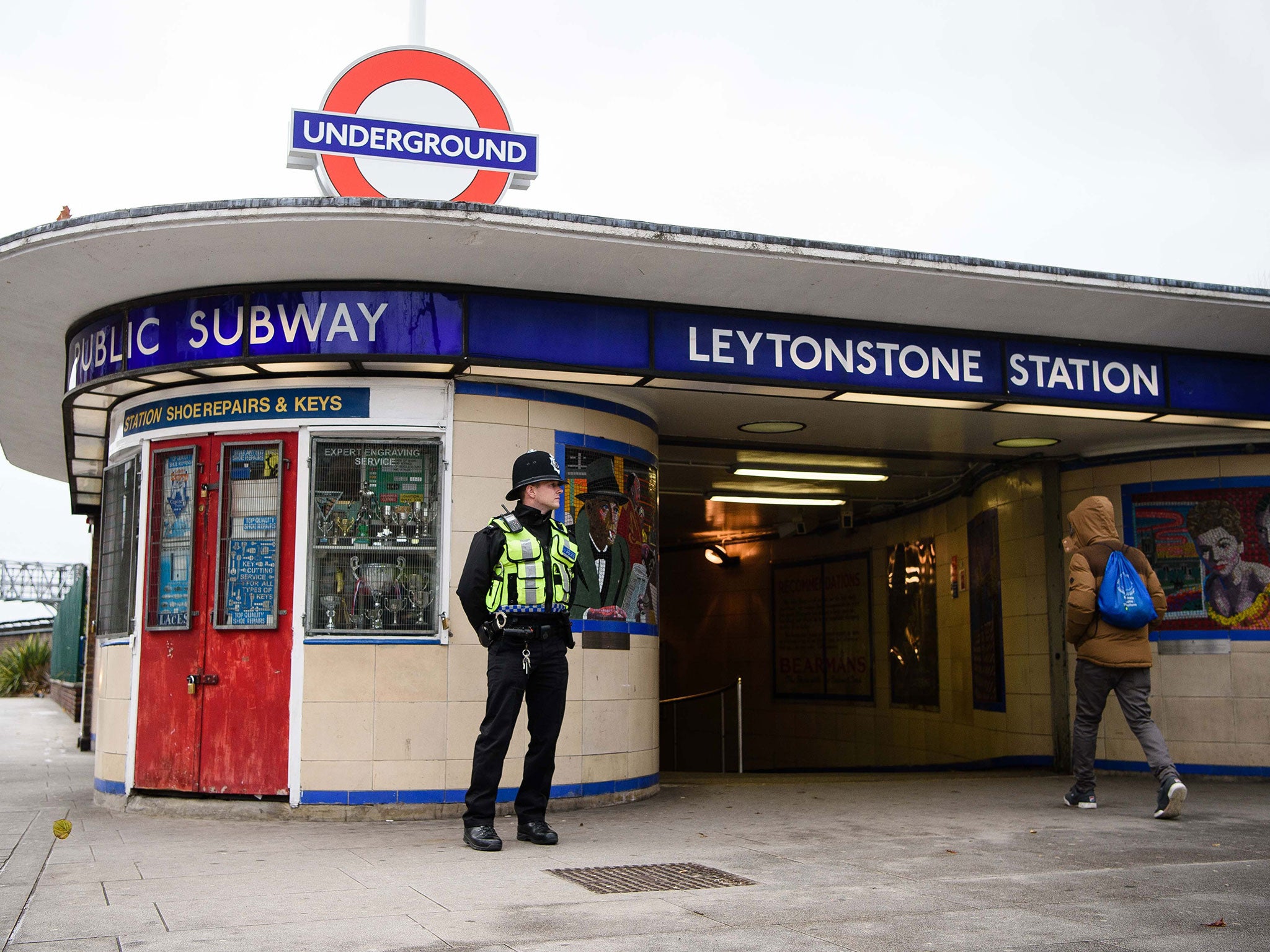 A police officer stands guard outside Leytonstone station in north London on December 6, 2015, a day after three people were stabbed in what police are treating as a 'terrorist incident'