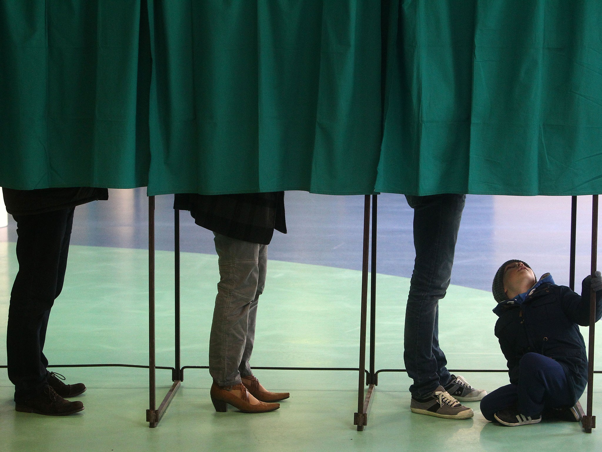 Voters stand in a polling booth during first round of regional elections, in Henin-Beaumont