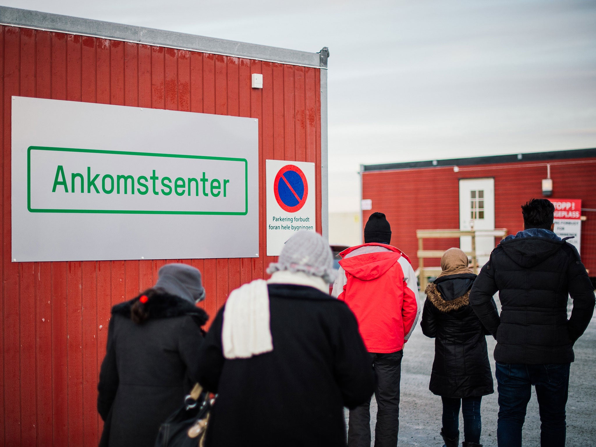 Refugees enter the arrival centre for refugees near the town on Kirkenes, northern Norway, close to the Russian - Norwegian border on November 12, 2015.