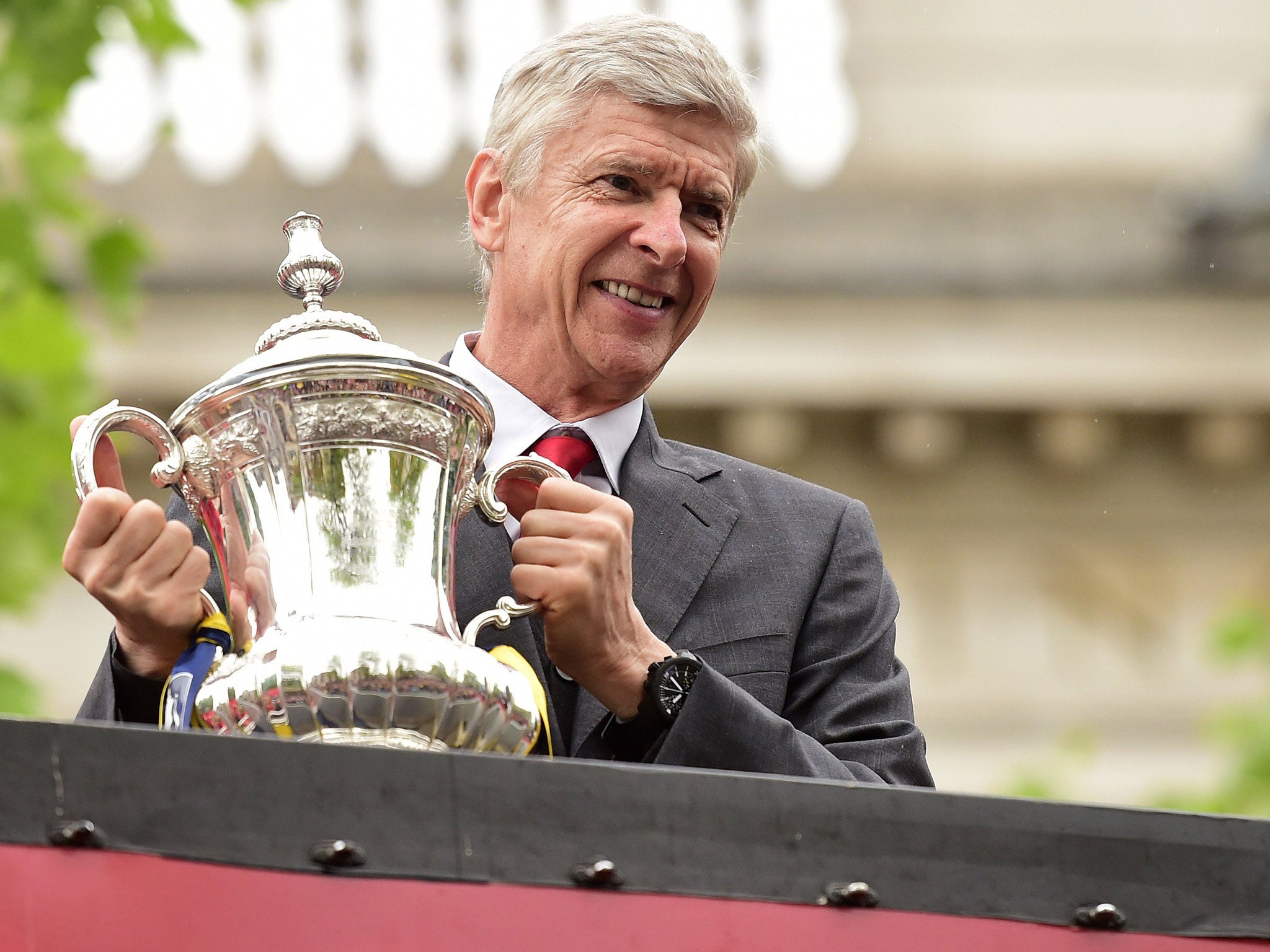 Arsenal Arsene Wenger holds the FA Cup trophy, which his team are the holders of