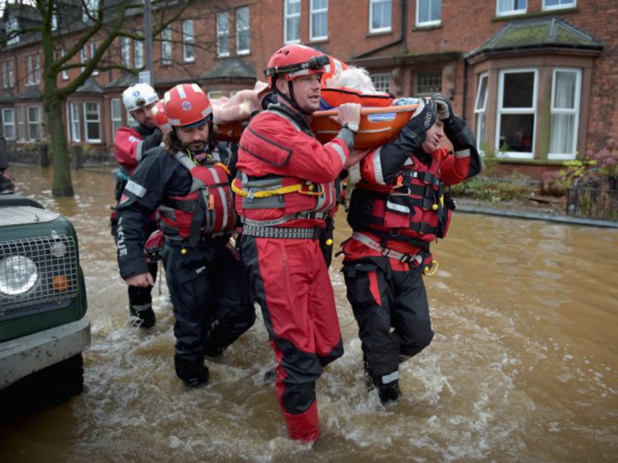 Rescue workers help to evacuate people from their homes in Carlisle