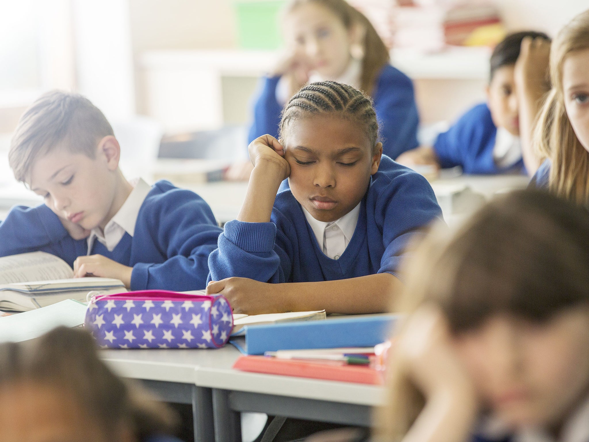 A tired child at school as a survey reveals why parents are keeping pupils at home