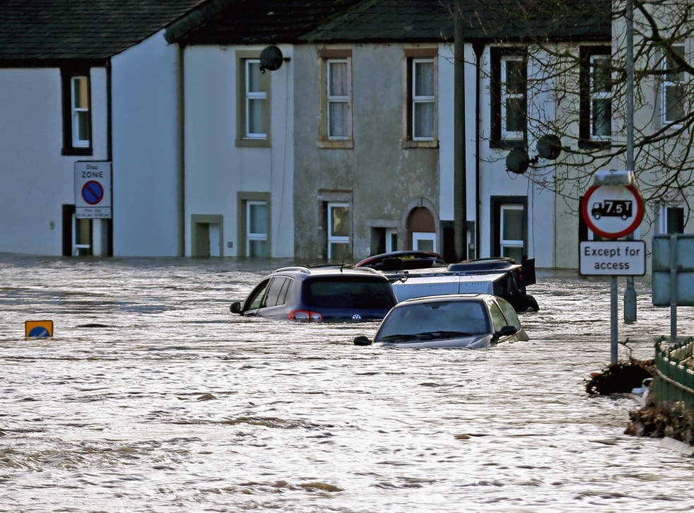 Water rises above cars as flooding blights the market town of Cockermouth