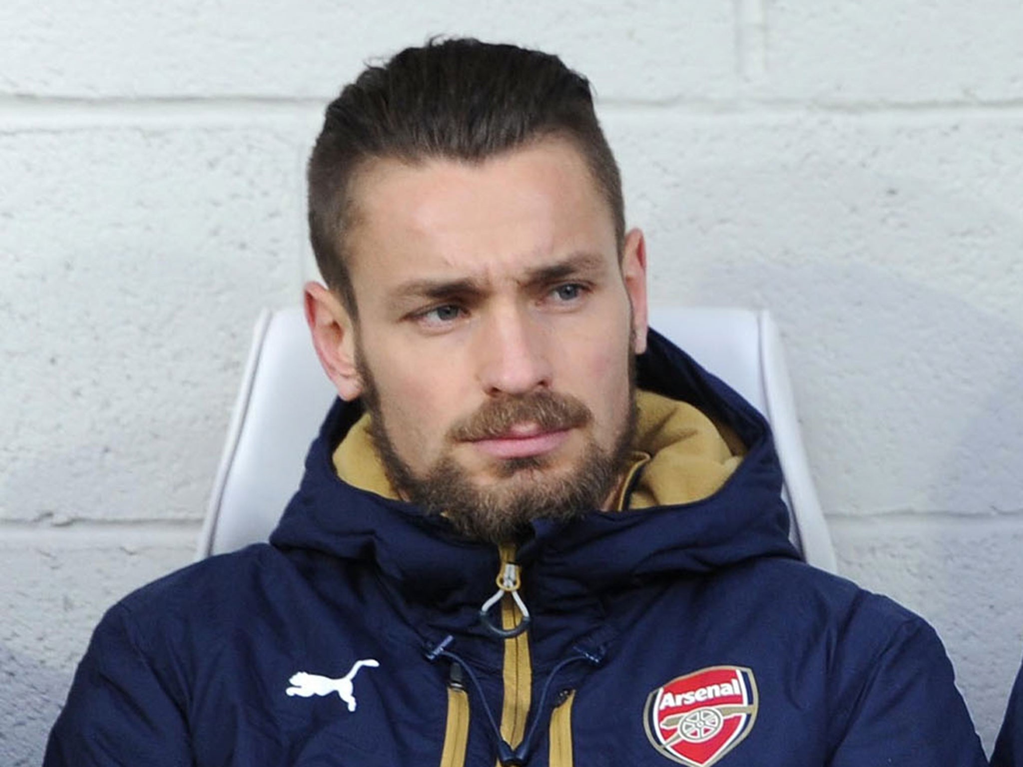 Mathieu Debuchy looks on from the bench at Arsenal