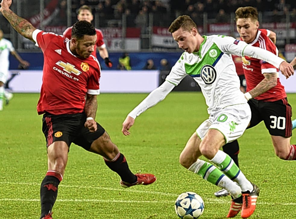Wolfsburg midfielder Julian Draxler takes on Manchester United winger Memphis Depay 