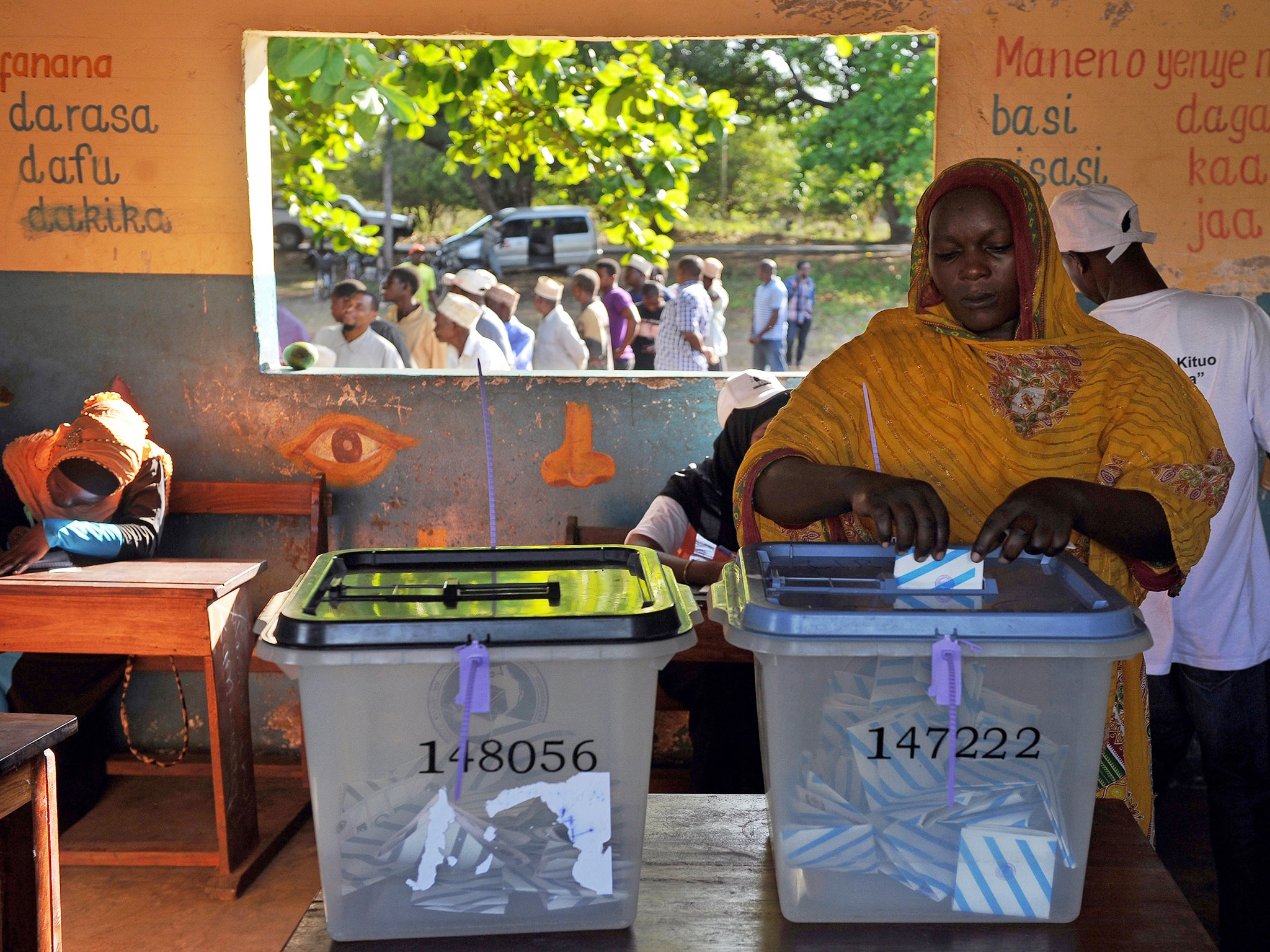 A Tanzanian woman casts her ballot for the Tanzanian presidential elections in Zanzibar
