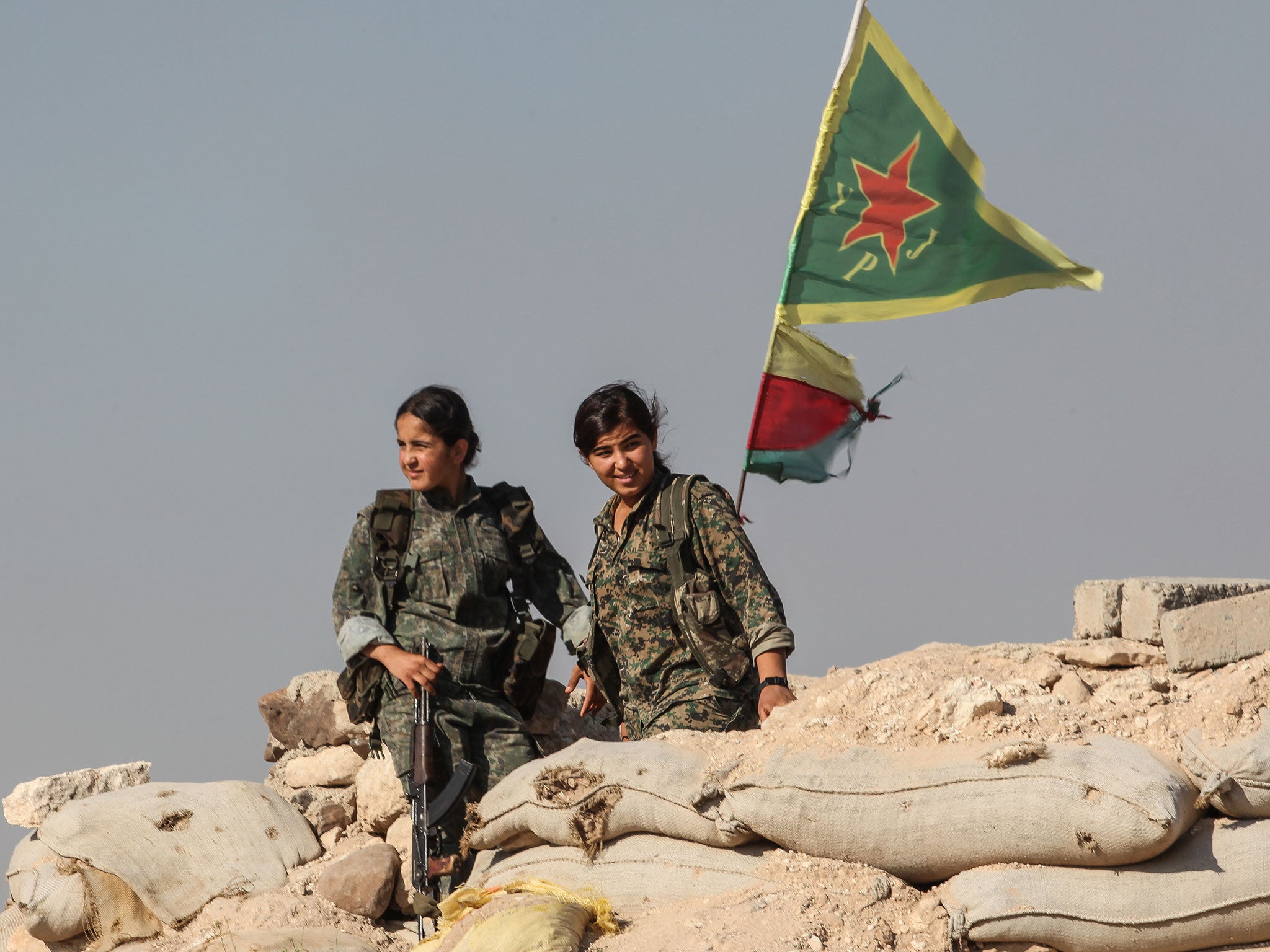 Members of the Kurdish People's Protection Units at a checkpoint in the outskirts of the Syrian town of Ain al-Arab (Kobani) which they freed from Isis in 2015