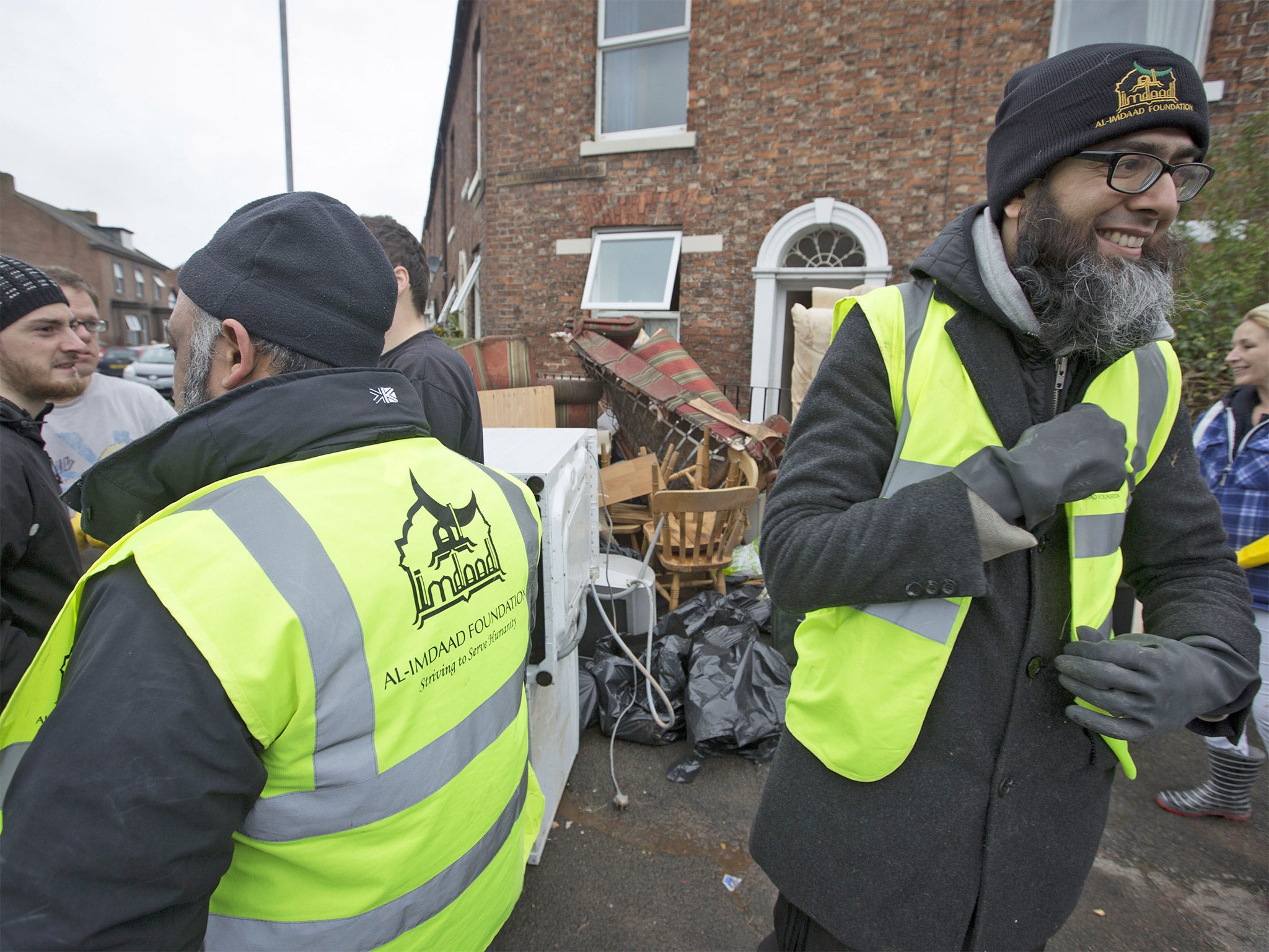 Members of the Al-Imdaad Foundation help remove furniture from a house in Carlisle