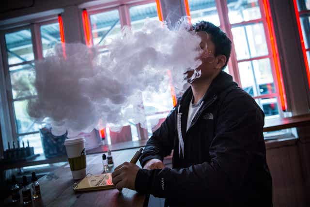 A man vapes in a New York e-cigarette shop
