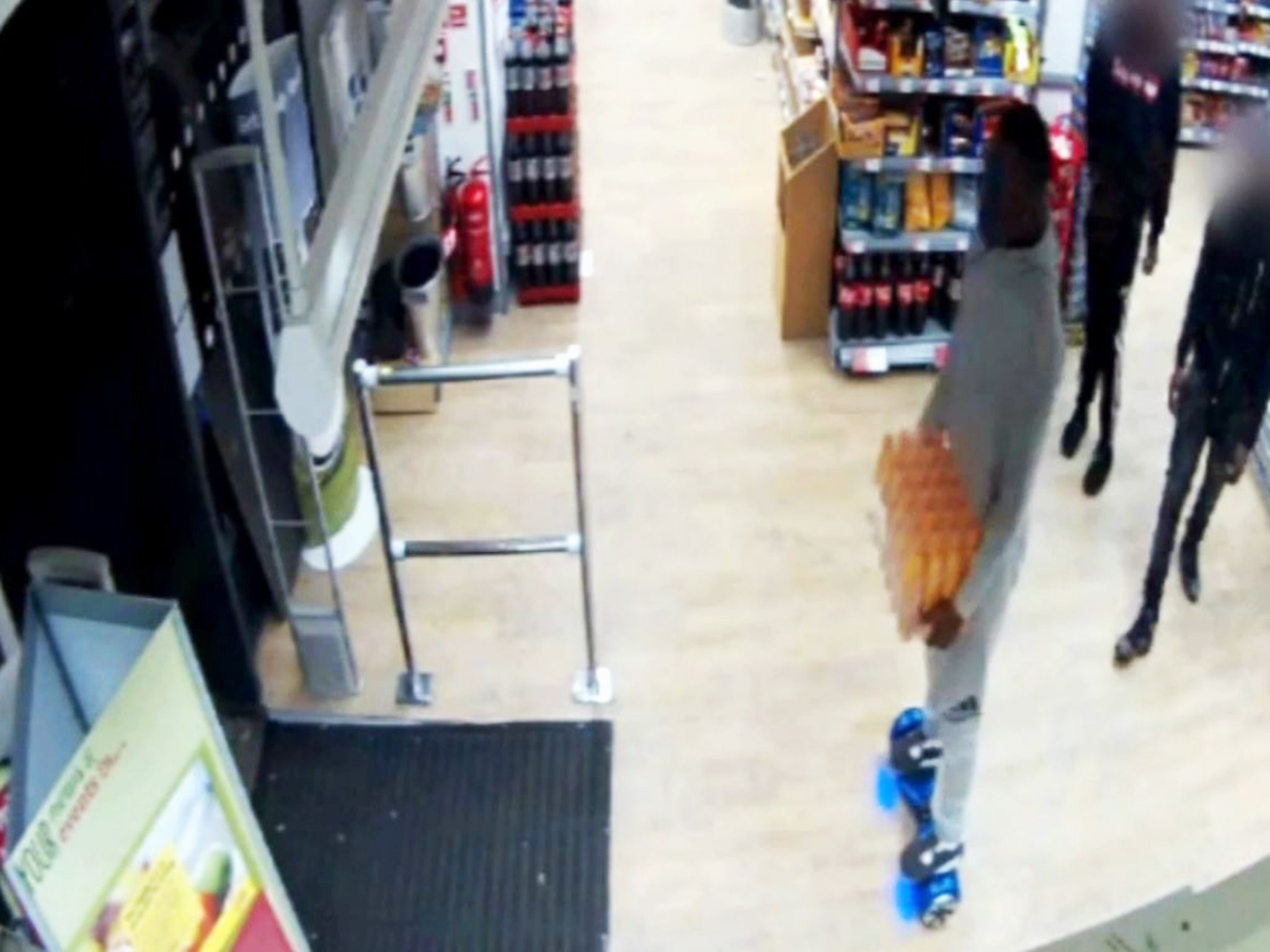 The man on the hoverboard appears to leave the store without paying for the crate of Lucozade
