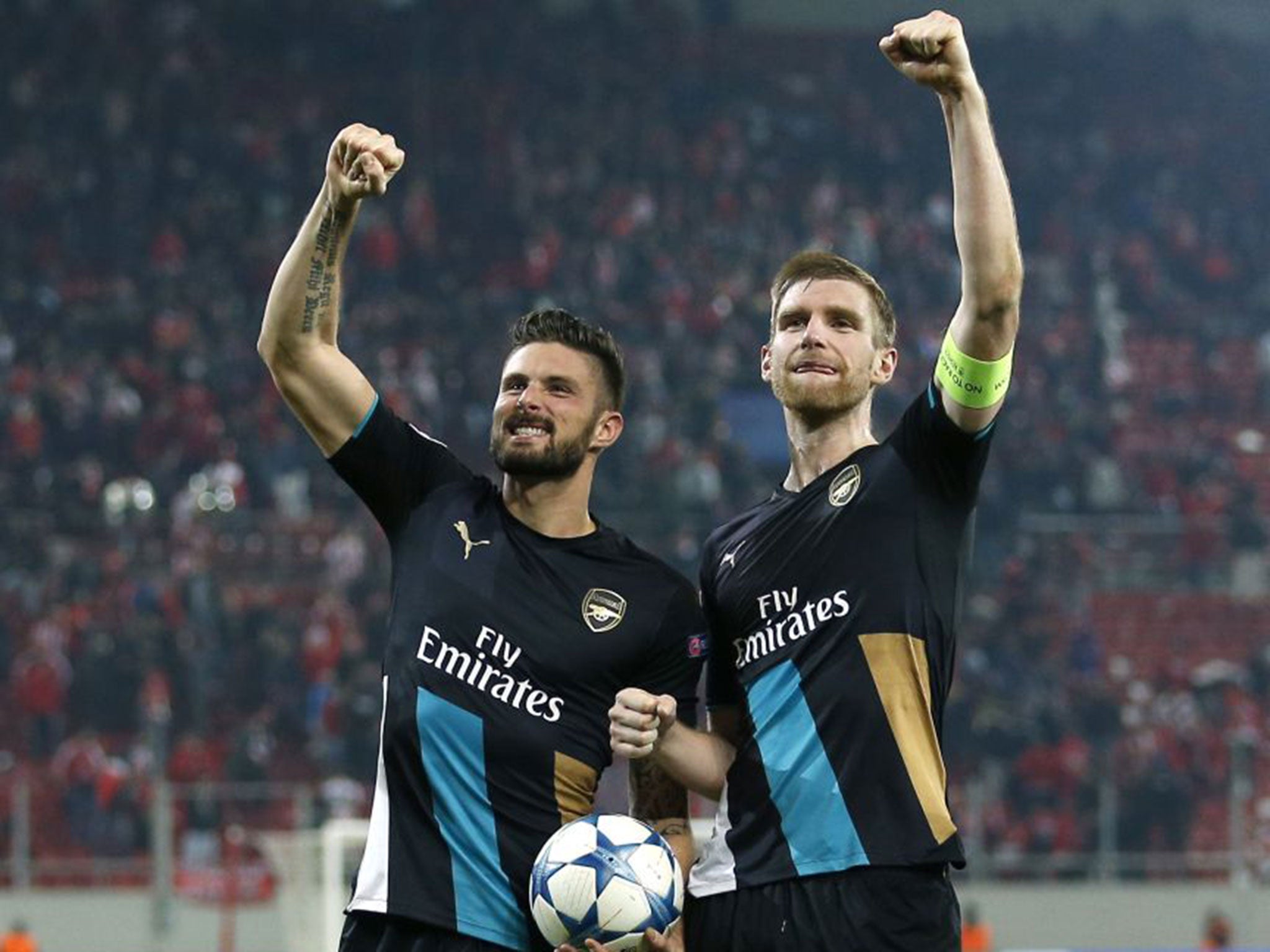Arsenal’s Olivier Giroud, left, celebrates with Per Mertesacker and the match ball after scoring a hat-trick against Olympiakos