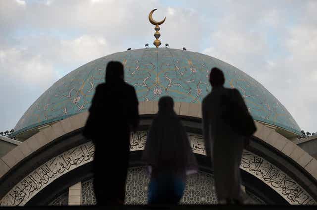Muslims walk towards a mosque