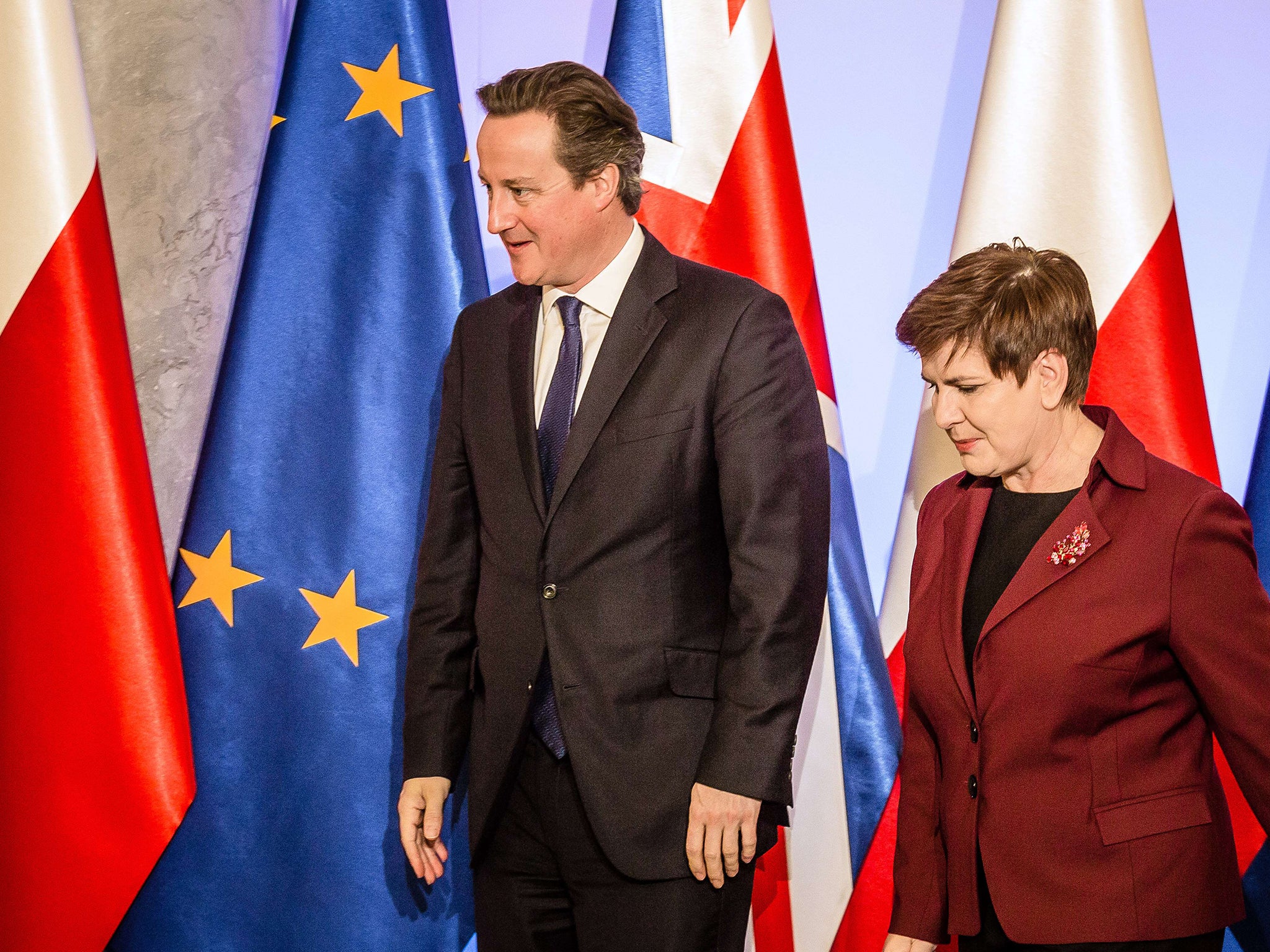 British Prime Minister David Cameron is followed by Polish counterpart Beata Szydlo (R) during an official welcoming ceremony at the Polish government building