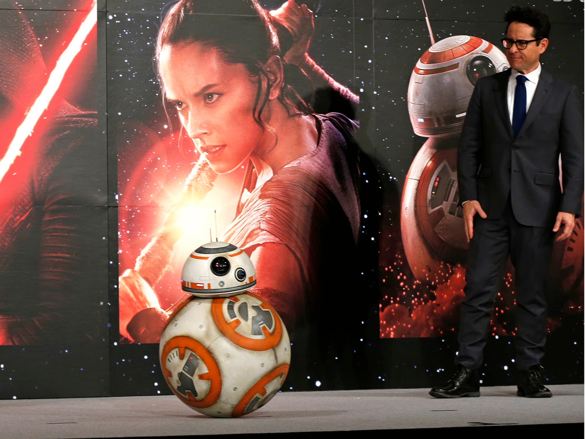 Director J.J. Abrams watches BB-8 droid moving during a press conference"Star Wars: The Force Awakens" at a hotel in Urayasu, near Tokyo