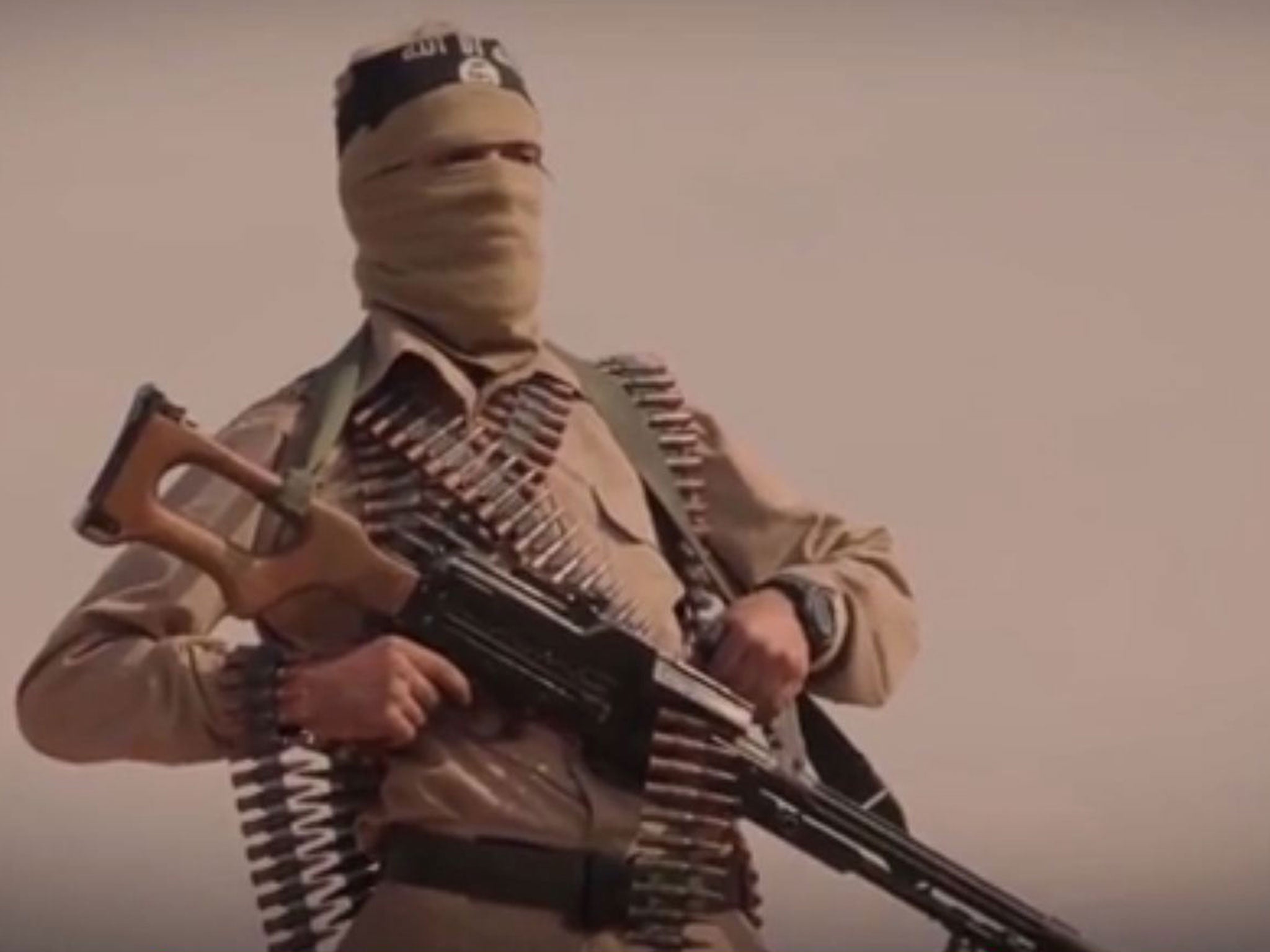 An Isis fighter poses with a light machine gun