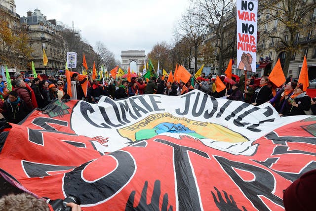 Protesters outside the talks in Paris. French foreign minister Laurent Fabius said the draft deal acknowledged the concept of 'climate justice' - a key demand from campaigners and a coalition of at risk countries
