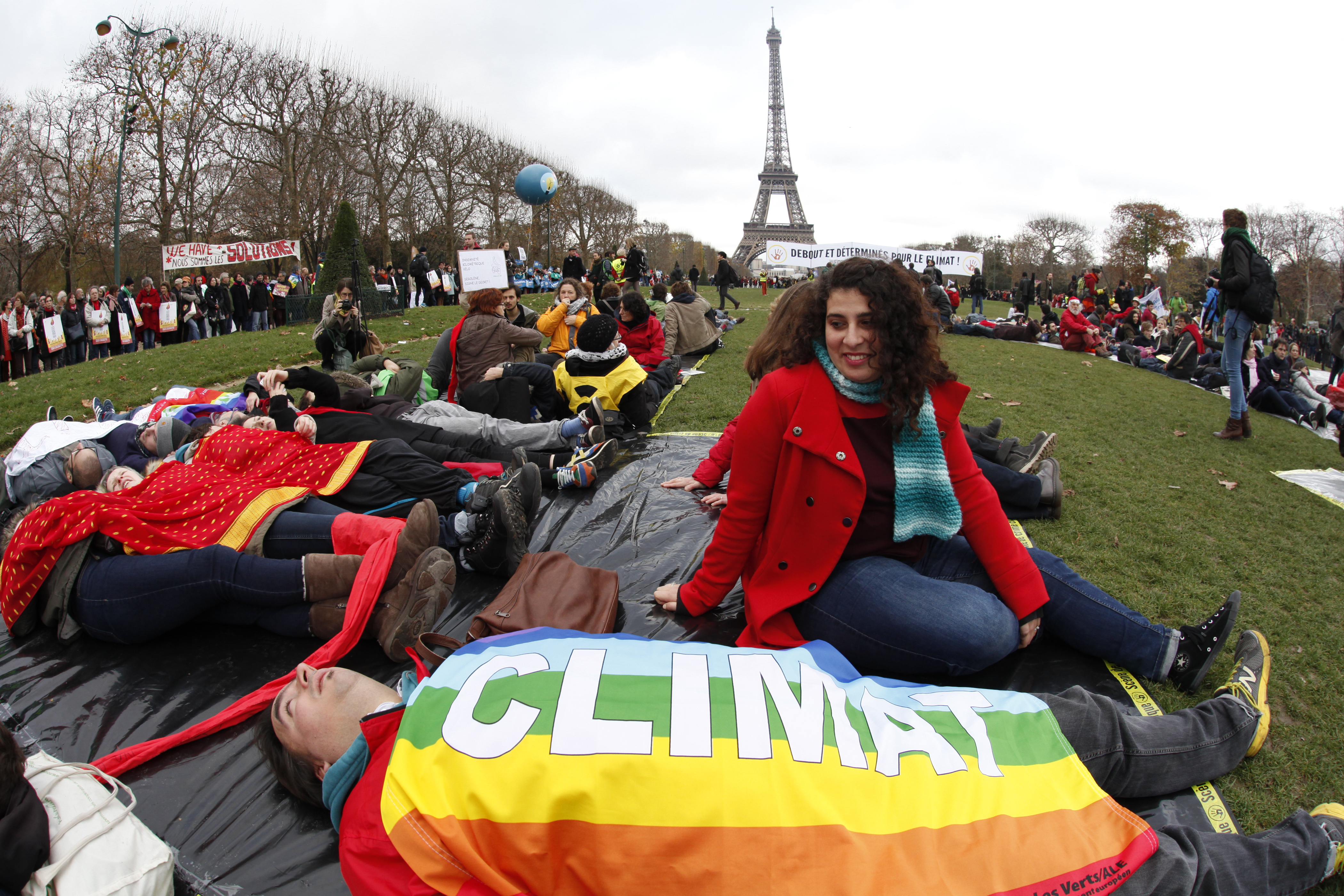 A man is covered with a multi-coloured banner with the message, "Climate" as environmentalists attend a demonstration near the Eiffel Tower in Paris, France, during the World Climate Change Conference 2015 (COP21) that meets in Le Bourget, December 12, 2015