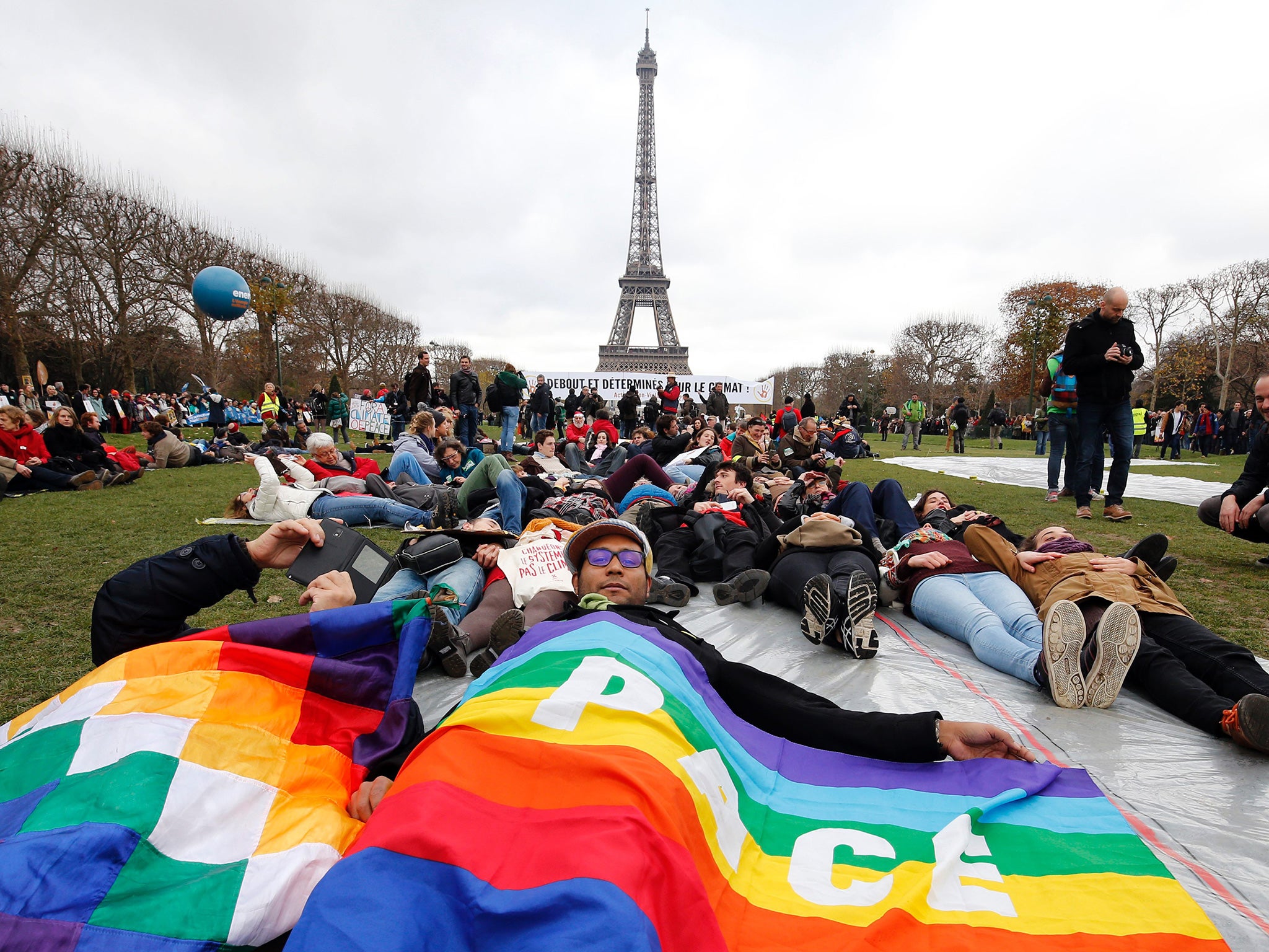 A demonstrator holds a peace flag during a rally called by several Non Governmental Organisations (NGO) to form a human chain on the Champs de Mars near the Eiffel Tower in Paris on the sidelines of the COP21 summit
