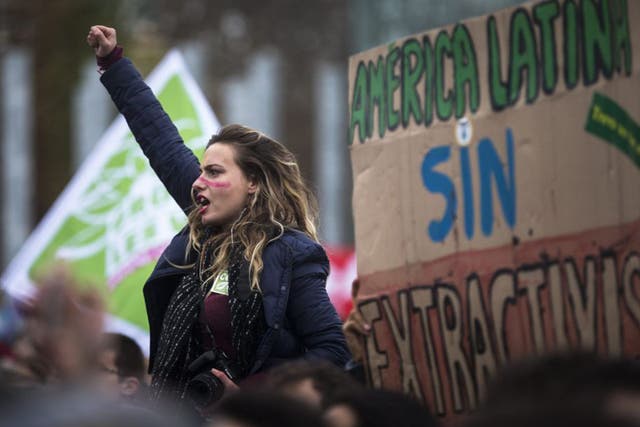 A young woman is one of thousands of people demonstrating in front of the Eiffel Tower in Paris. The final draft of the agreement at COP21 has received a largely positive response although there are concerns it does not go far enough to tackle climate change