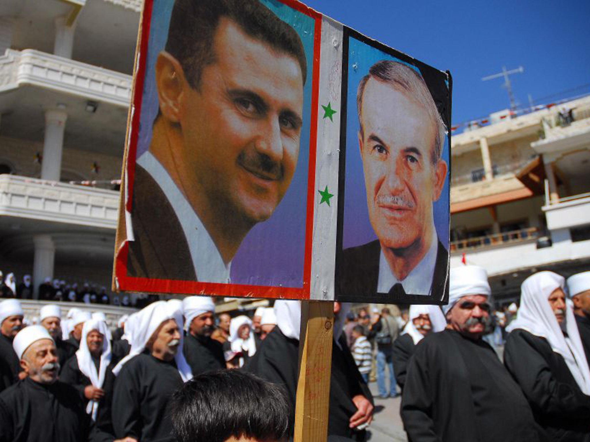 Supporters with a poster of Bashar al-Assad and his father, Hafez