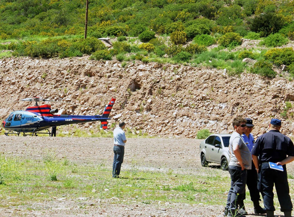 Policemen standing near a police helicopter after an MTV helicopter crashed in Potrerillos, some 30 km southeast of Mendoza, Argentina on December 12, 2015
