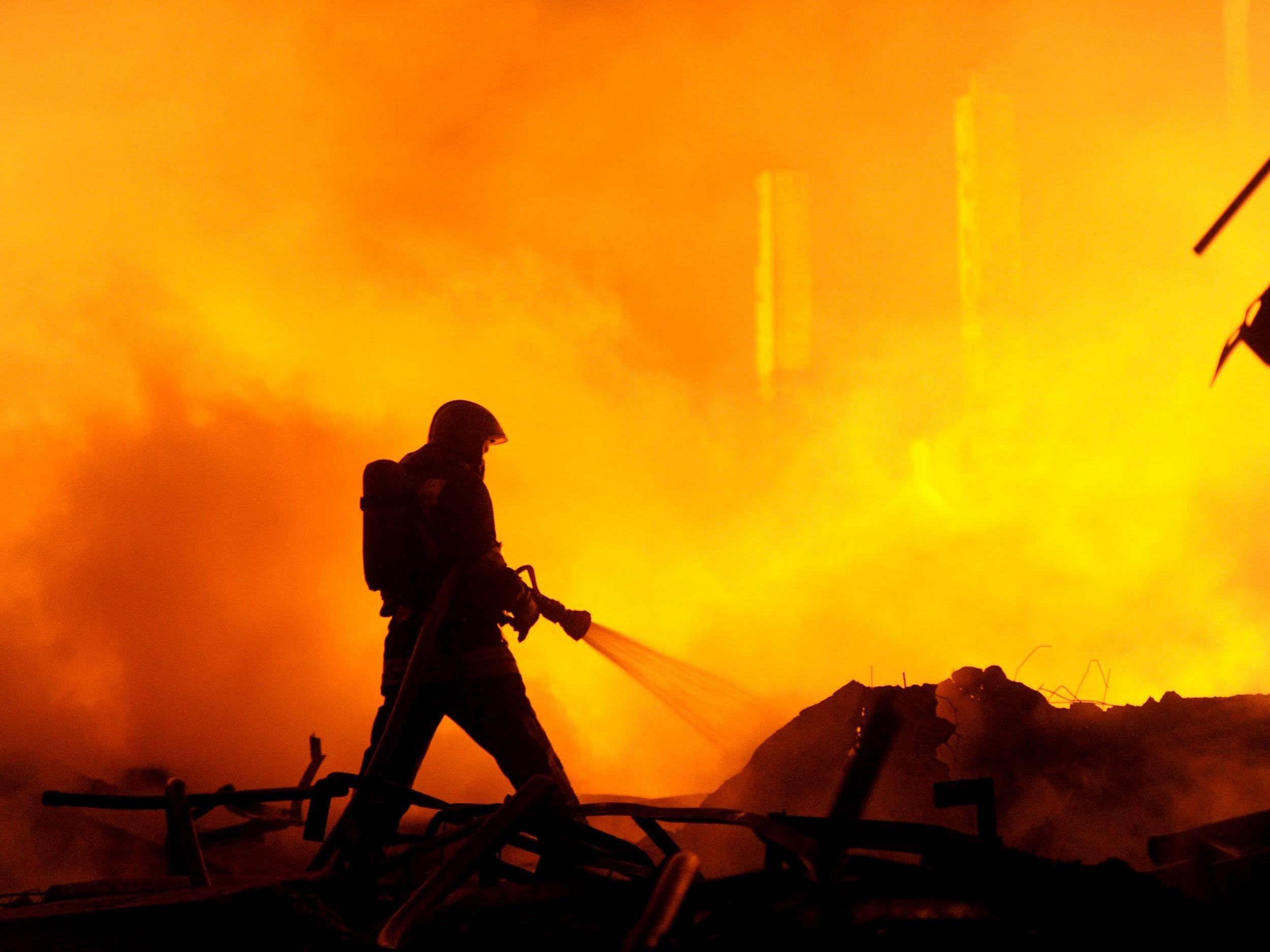 A firefighter works to extinguish a previous fire in Russia