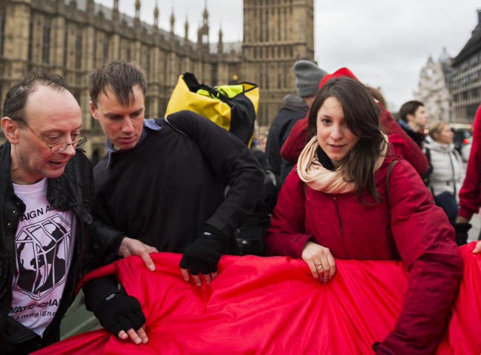 Climate change activists campaigning to limit emissions with a red banner to symbolise a ‘red line’ on Westminster Bridge on Saturday