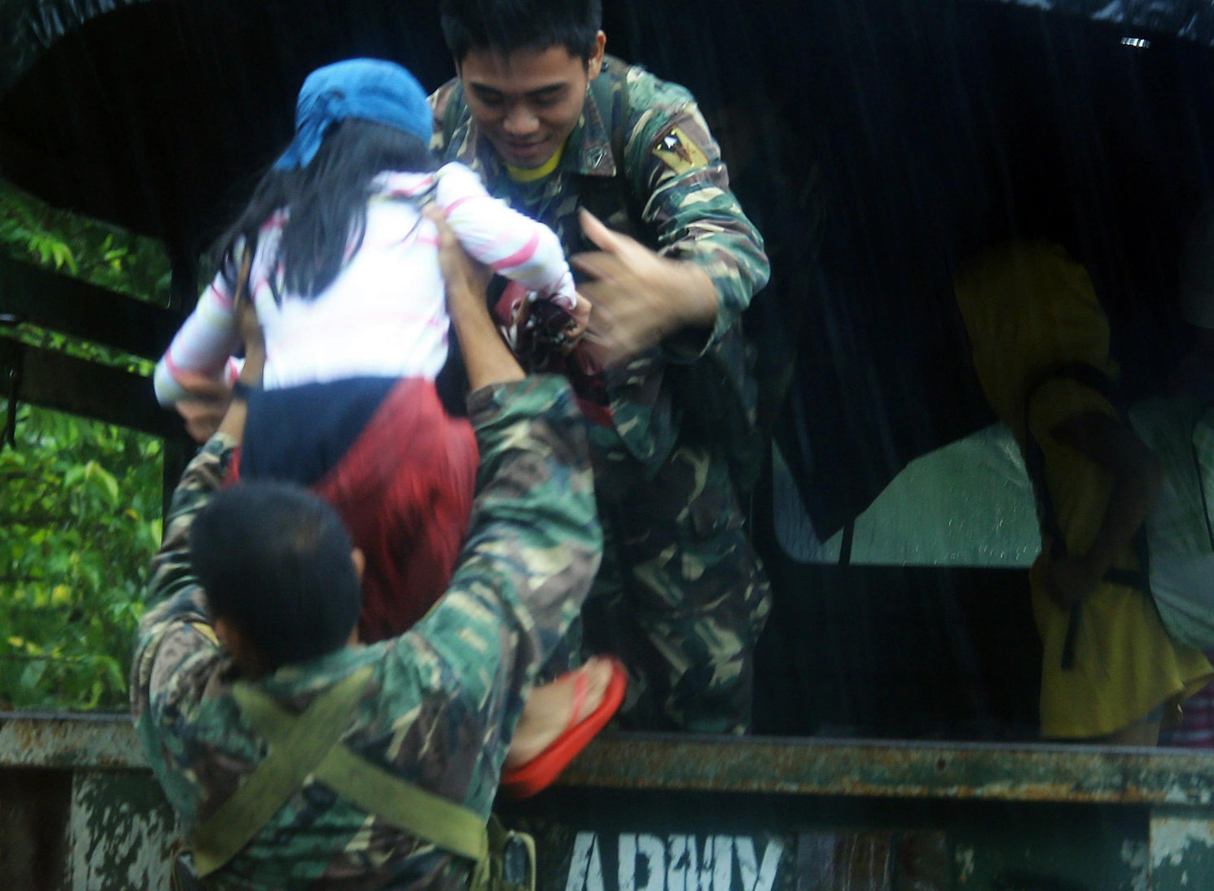 Military personnel evacuate residents in the city of Legaspi as Typhoon Melor approaches.