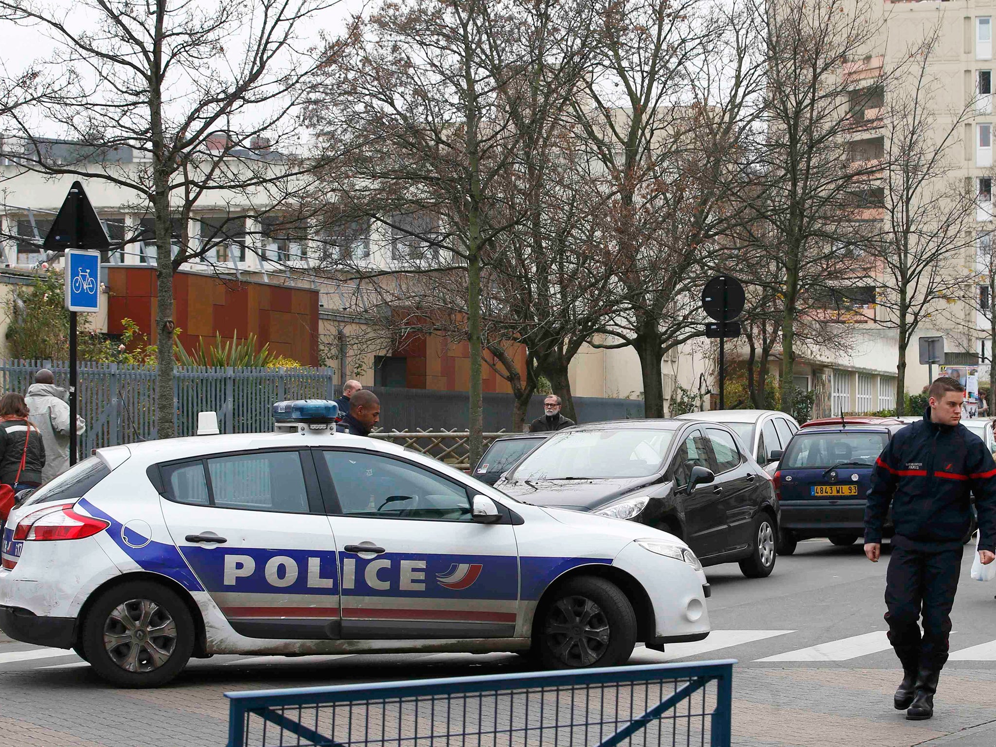 French police and firefighters are seen in front of the nursery school where a hooded man claiming to be acting for Isis attacked a teacher with a knife in Aubervilliers, near Paris