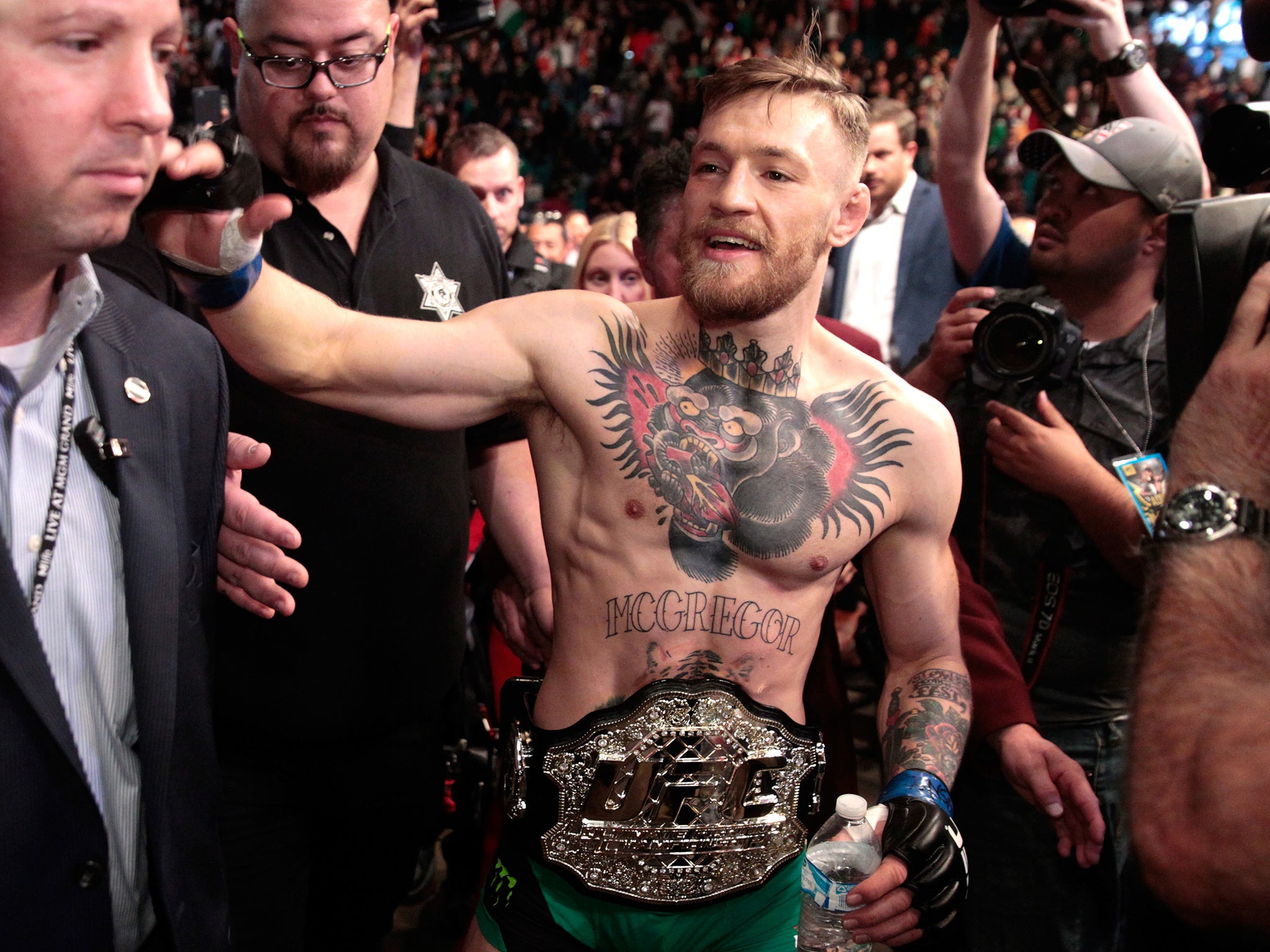 Conor McGregor walks back to his dressing room after his triumph over Jose Aldo at UFC 194