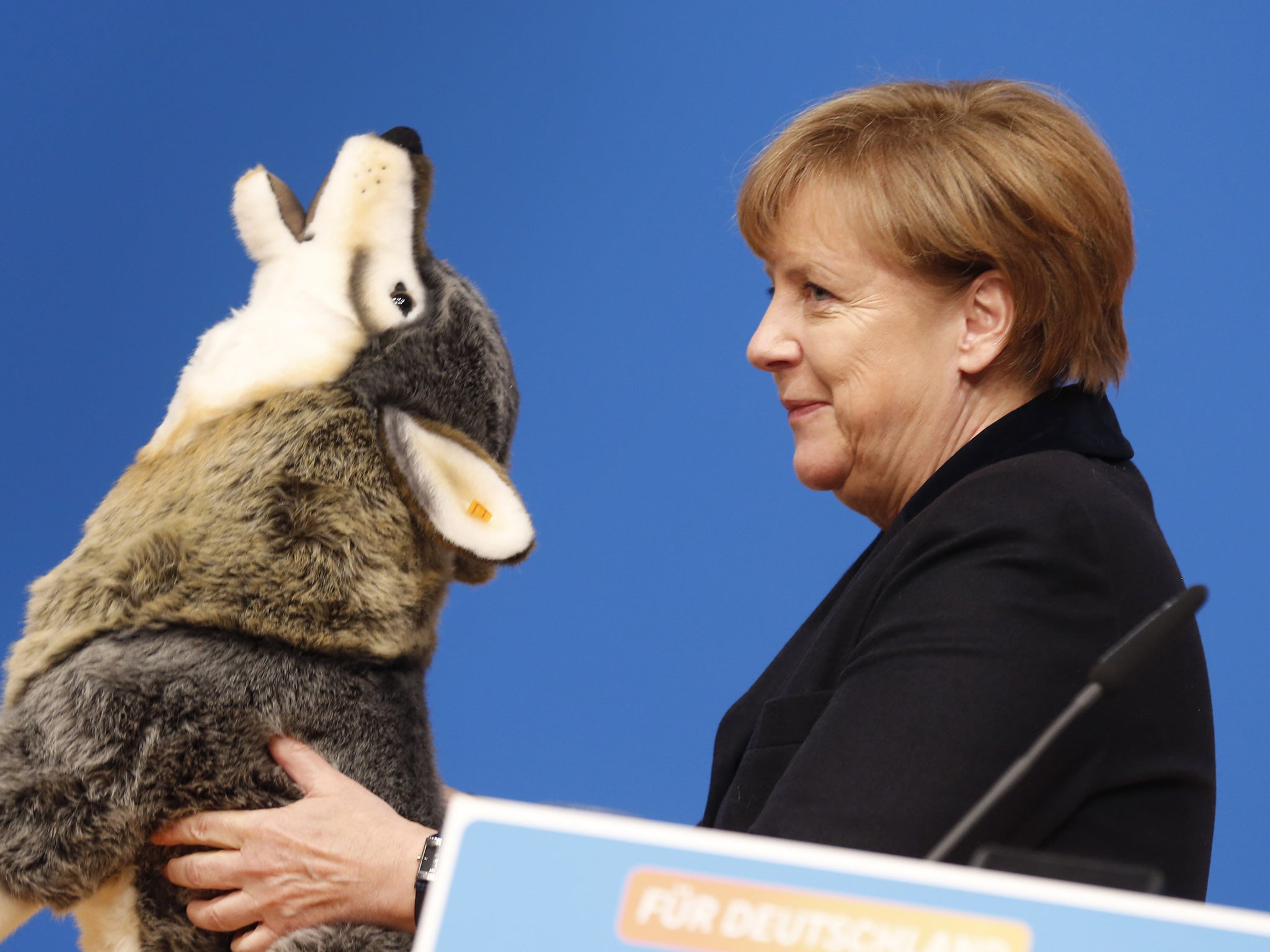 Chancellor Angela Merkel, holding a toy wolf gift at a Christian Democrat convention in Karlsruhe, addressed party members with a speech designed to take the bite out of her critics