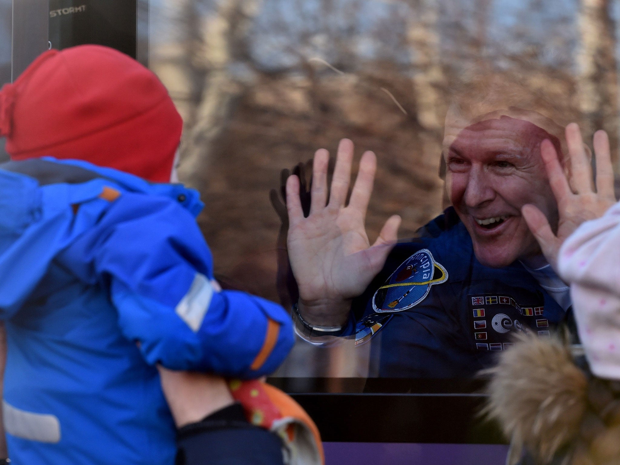 British astronaut Tim Peake waves from a bus during a sending-off ceremony at the Baikonur Cosmodrome on December 15, 2015.