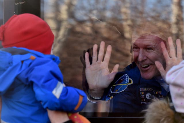 British astronaut Tim Peake waves from a bus during a sending-off ceremony at the Baikonur Cosmodrome on December 15, 2015.