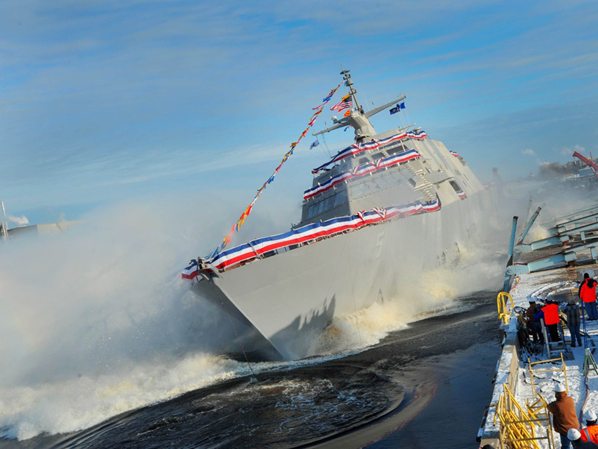 The littoral combat ship Pre-Commissioning Unit (PCU) Milwaukee (LCS 5) slides into the Menominee River