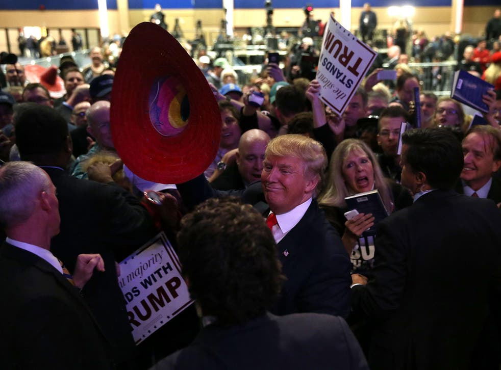 Republican presidential candidate Donald Trump holds a sombrero as he greets supporters during a campaign rally at the Westgate Las Vegas Resort & Casino on 14 December