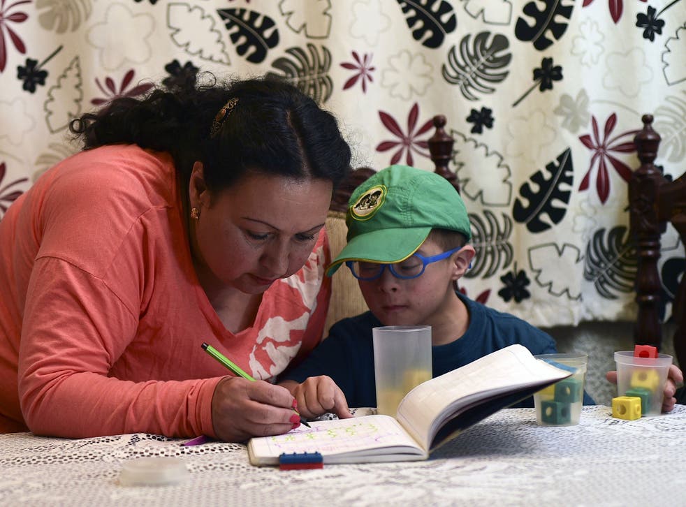 Colombian priest Aida Soto helps her son with his homework in Bogota on March 5, 2015. Soto is one of four Latin American women priests, member of the Roman Catholic Women Priests Association