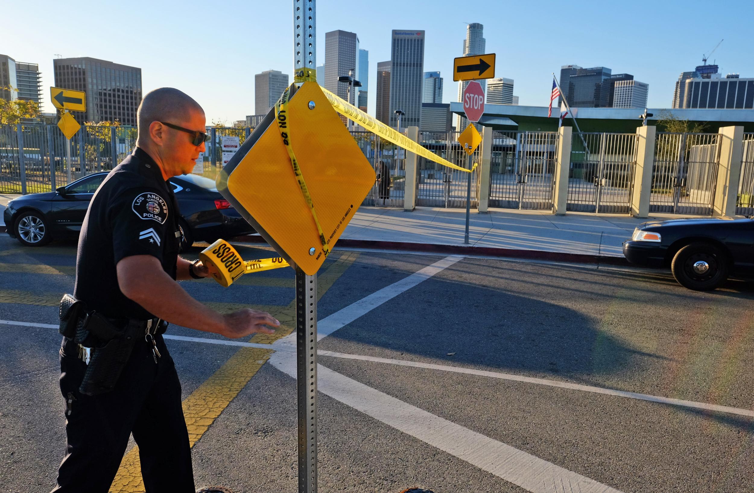 A police officer tapes off the entrance near the Edward Roybal High School in Los Angeles.