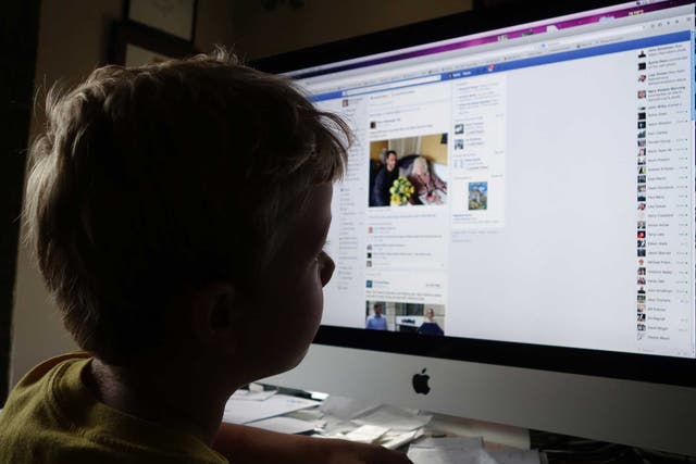 A child examines his Facebook homepage