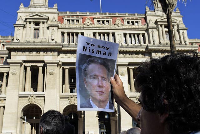 A man holds a portrait of late Argentine prosecutor Alberto Nisman during a demonstration in demand of justice, in front of the law court in Buenos Aires, earlier this year