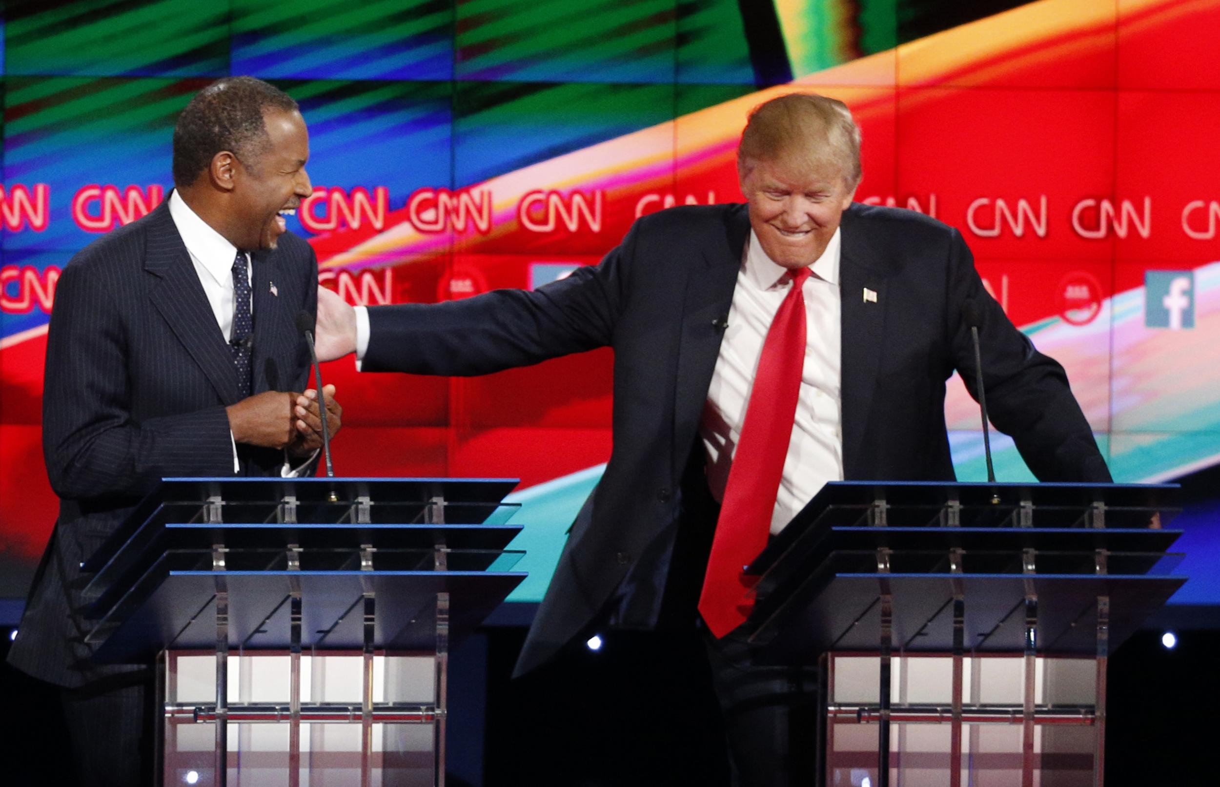 Ben Carson, left, and Donald Trump have a moment during Tuesday night's debate. John Locher/AP