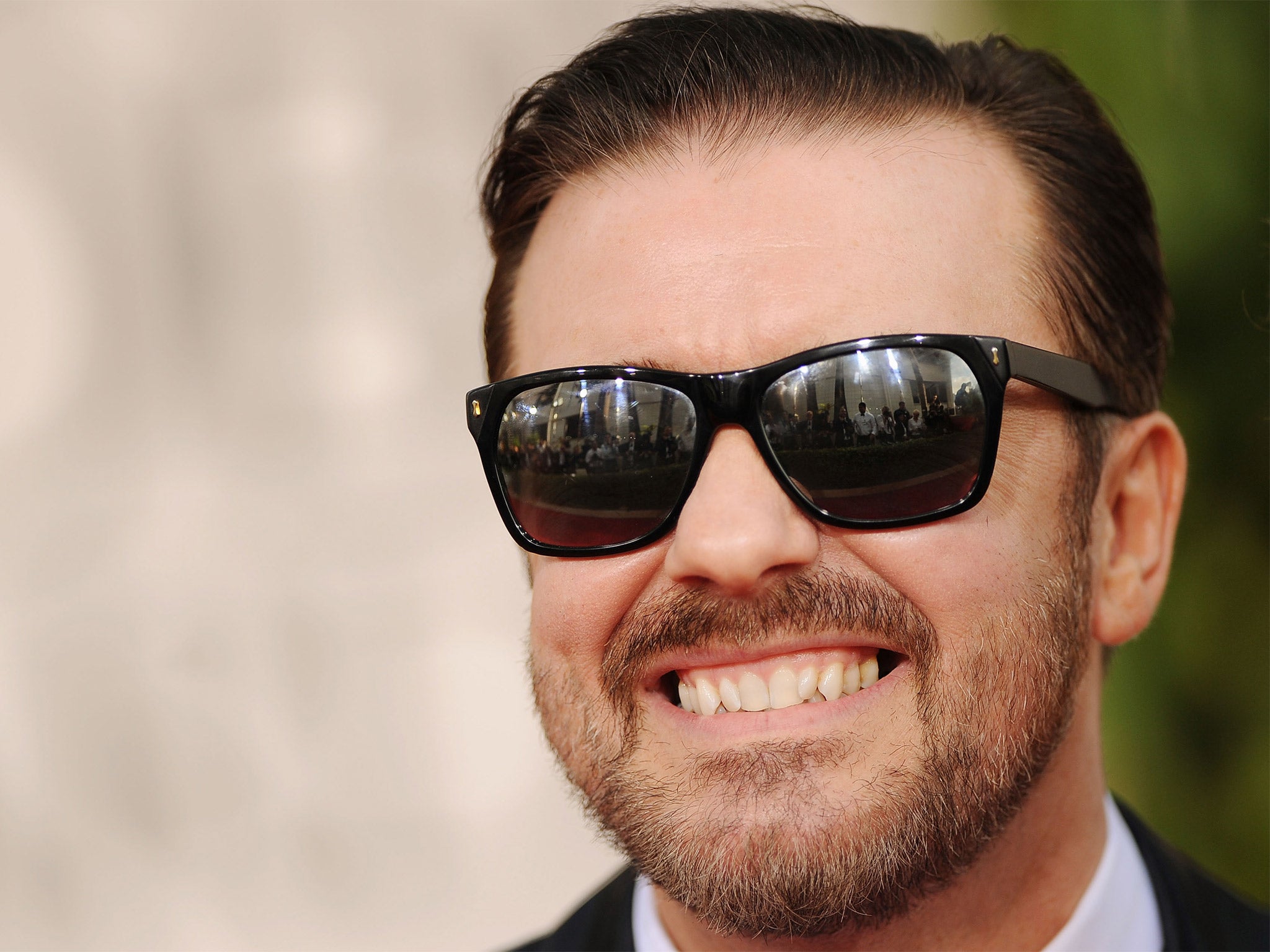Ricky Gervais said an American journalist praised him for wearing an awful set of false teeth at a film launch, even though he wasn’t